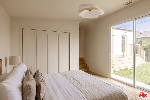 a bed sitting in a bedroom next to a window