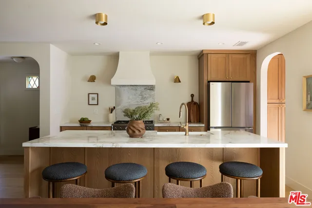 a kitchen with stainless steel appliances granite countertop a sink and a refrigerator