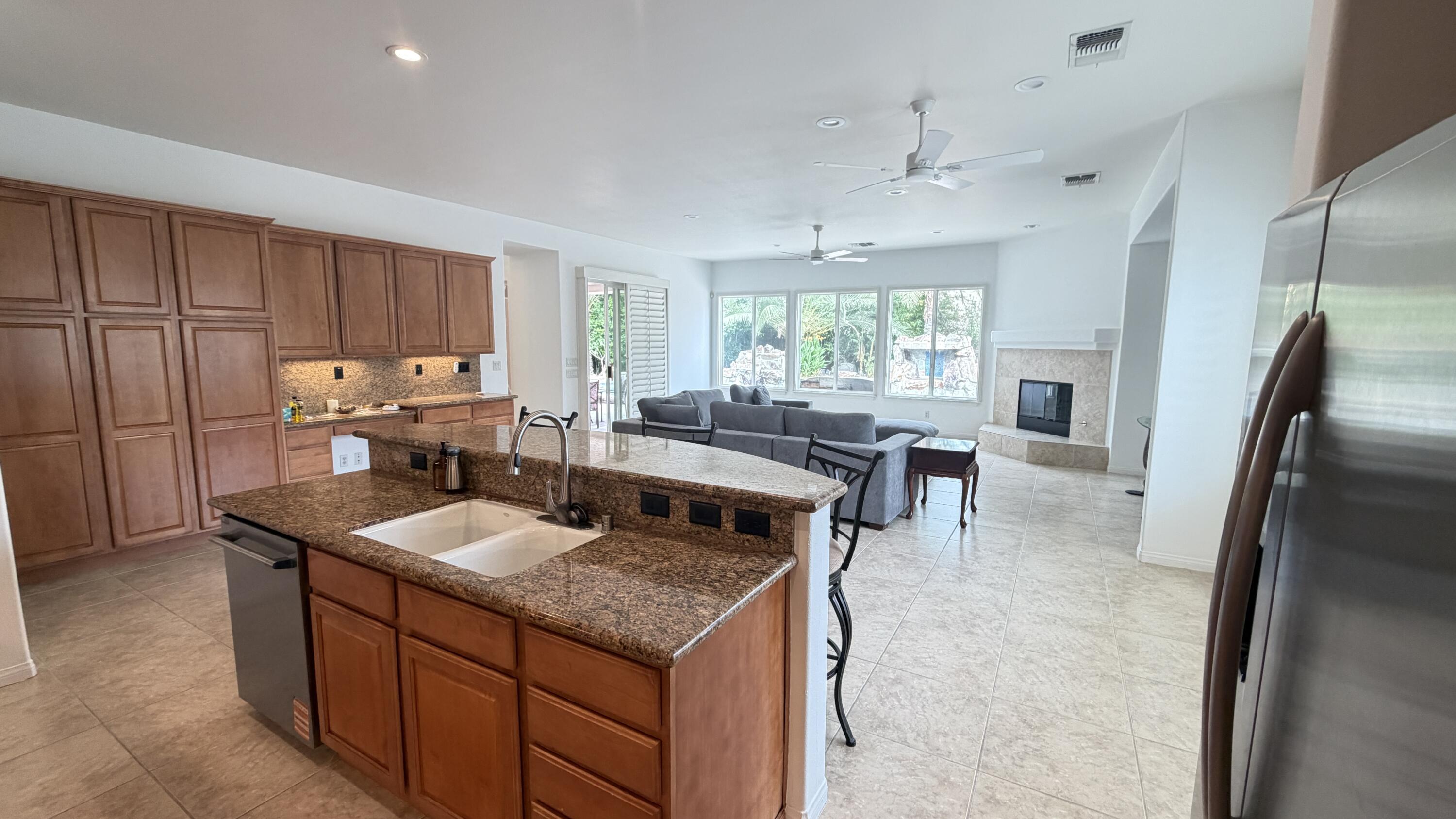 49578 Colorado Street Indio, CA 92201 - Photo 11 of 37 a kitchen with granite countertop a sink stove and refrigerator