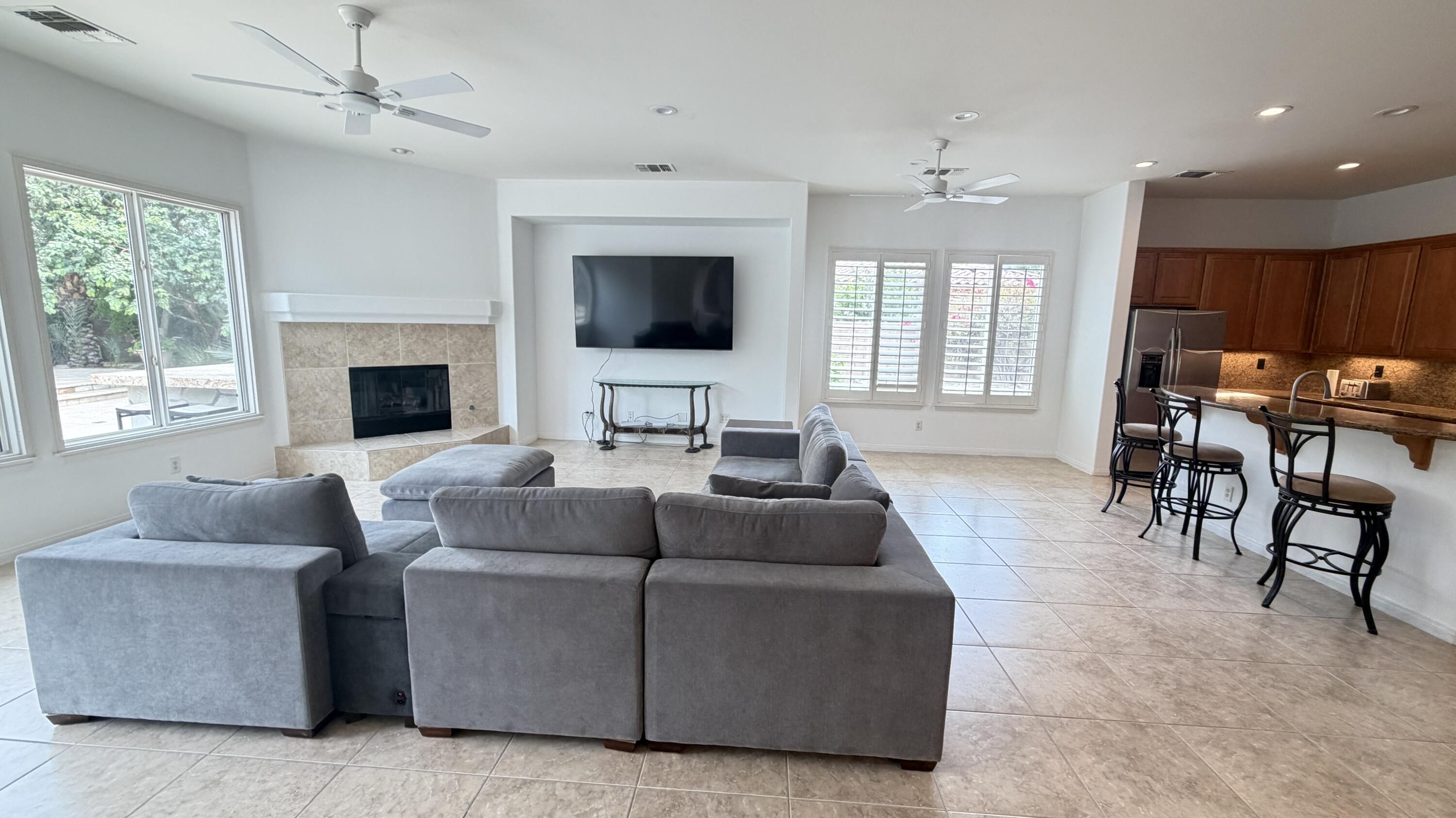 49578 Colorado Street Indio, CA 92201 - Photo 6 of 37 a living room with furniture a flat screen tv and a large window
