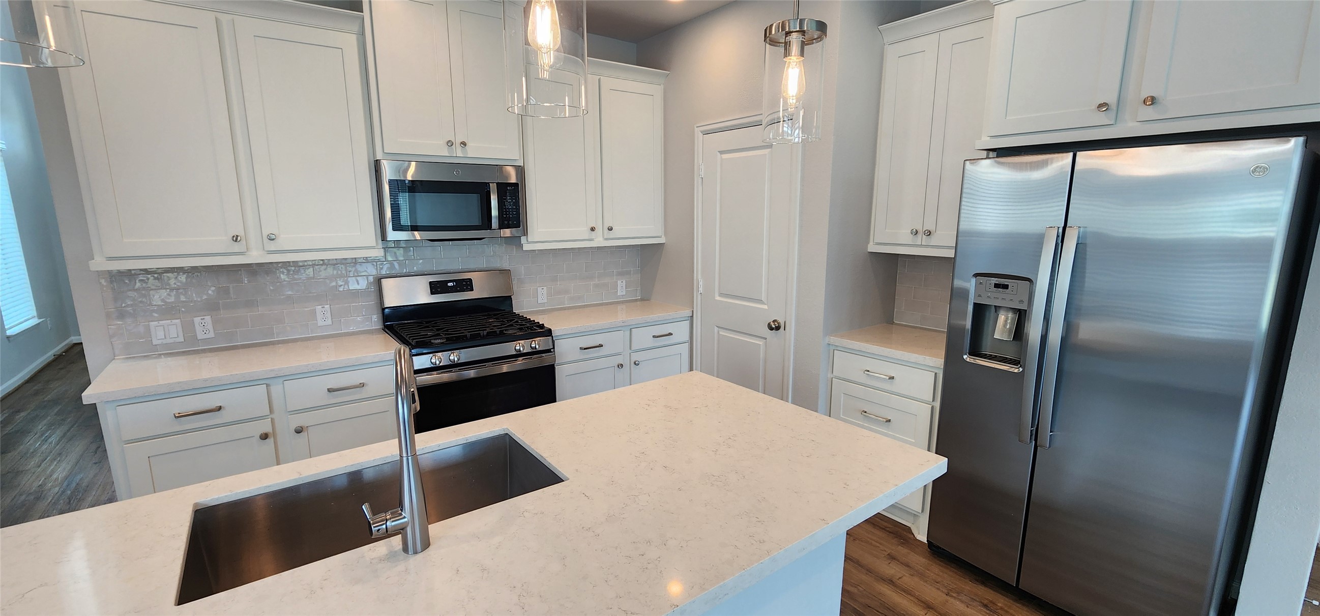 148 Los Olives Lane Georgetown, TX 78628 - Photo 11 of 38 Kitchen with stainless steel appliances, decorative backsplash, white cabinets, and pendant lighting