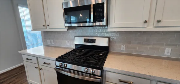 a kitchen with stainless steel appliances white cabinets and a refrigerator