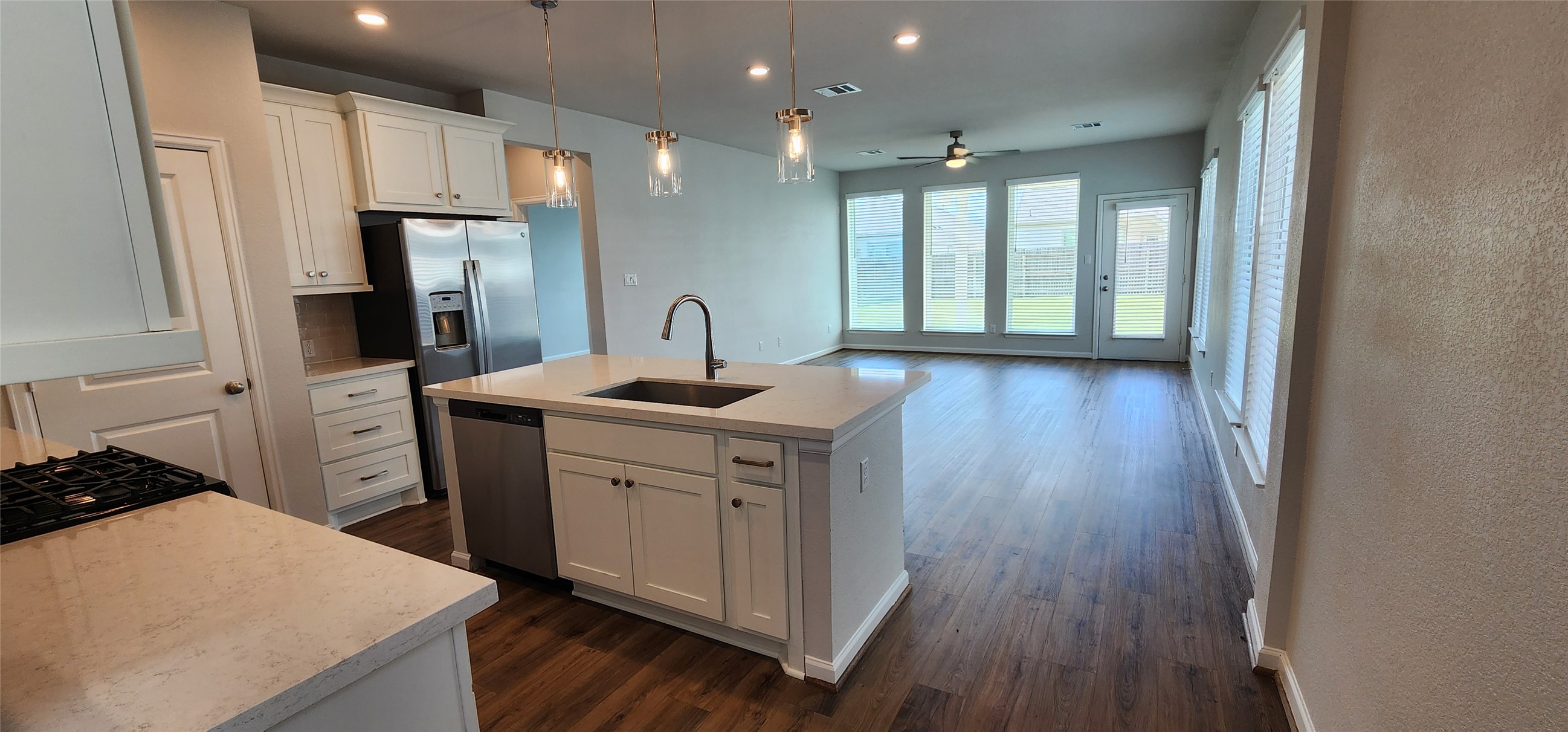 148 Los Olives Lane Georgetown, TX 78628 - Photo 38 of 38 Kitchen featuring a kitchen island with sink, white cabinetry, open floor plan, pendant lighting, and dark wood-style flooring