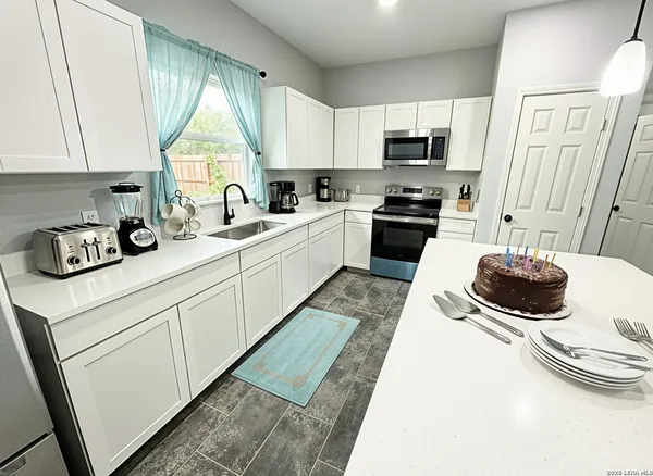 a kitchen with a sink a stove and a microwave