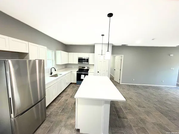 a kitchen with stainless steel appliances a refrigerator and a stove top oven