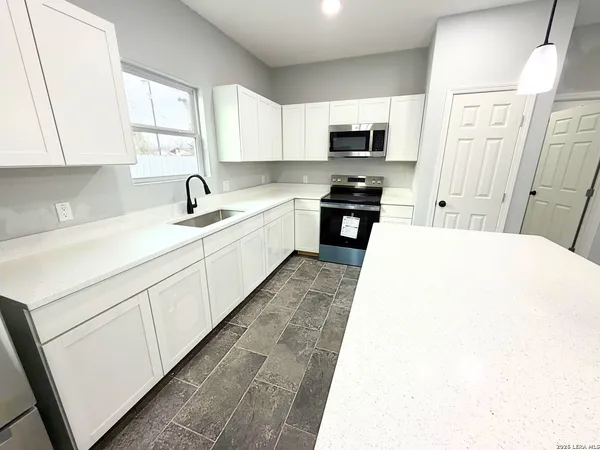 a kitchen with a sink a stove and cabinets