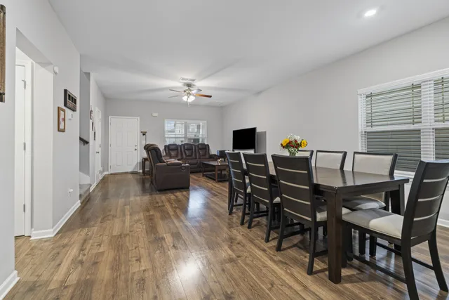 a living room with furniture a dining table and chairs with wooden floor