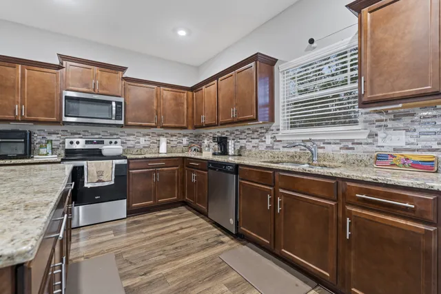 a kitchen with stainless steel appliances granite countertop a sink stove microwave and cabinets