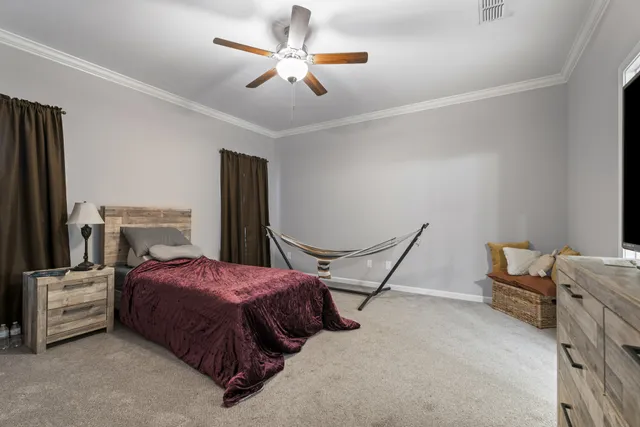 a bedroom with a bed a couch and a chandelier