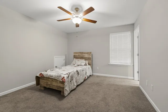 a bed sitting in a bedroom next to a window