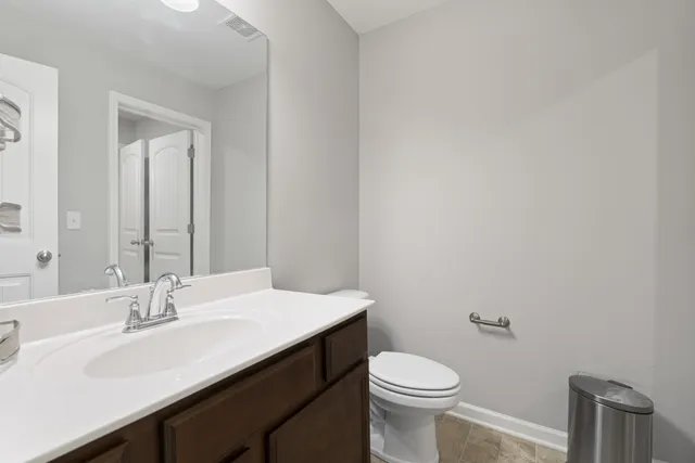 a bathroom with a sink a toilet and a mirror