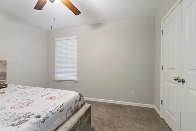a bedroom with a bed and a chandelier fan
