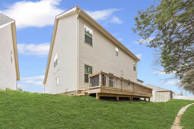 a view of house with backyard and deck