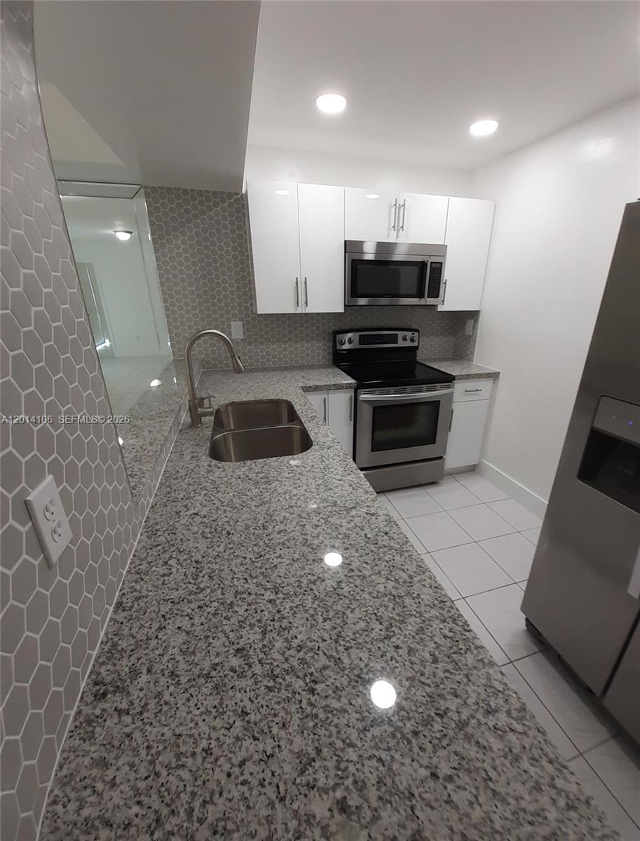 11800 Southwest 18th Street, Unit 3144 Miami, FL 33175 - Photo 3 of 23 a kitchen with kitchen island a counter top space and cabinets