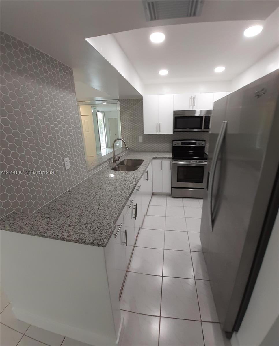 11800 Southwest 18th Street, Unit 3144 Miami, FL 33175 - Photo 4 of 23 a kitchen with stainless steel appliances granite countertop a refrigerator and a sink