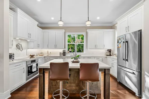 a kitchen with stainless steel appliances a dining table and chairs