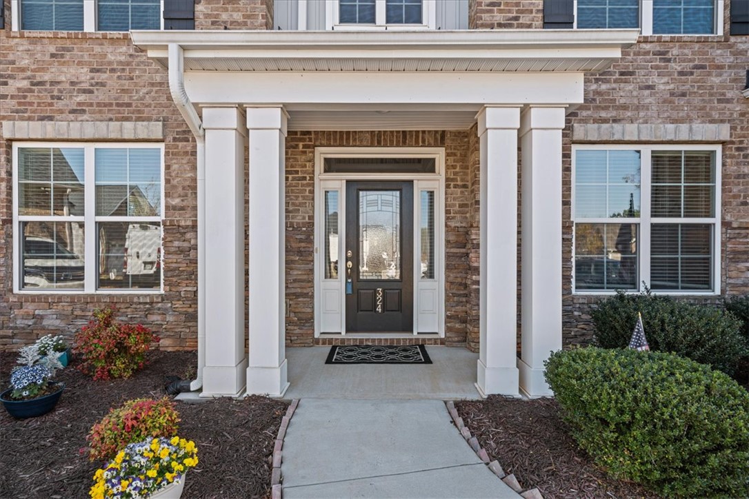 324 Crestgate Way Easley, SC 29642 - Photo 42 of 44 The welcoming entrance of this home features a charming porch and classic brick construction.