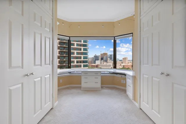 a large white room with a large window and chairs