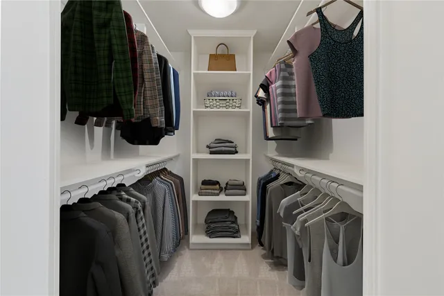 a view of walk in closet with clothes and shoes