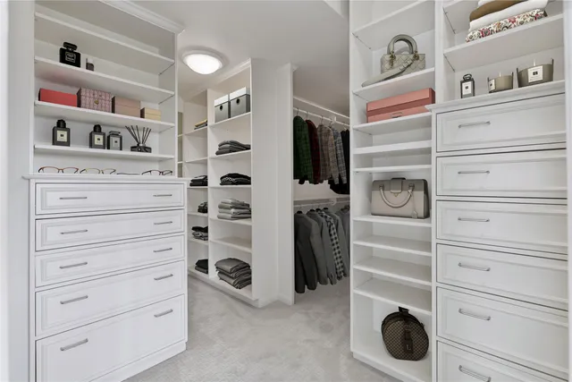 a view of walk in closet with clothes and shoes