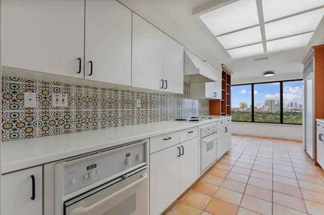 a kitchen with granite countertop white cabinets and white appliances