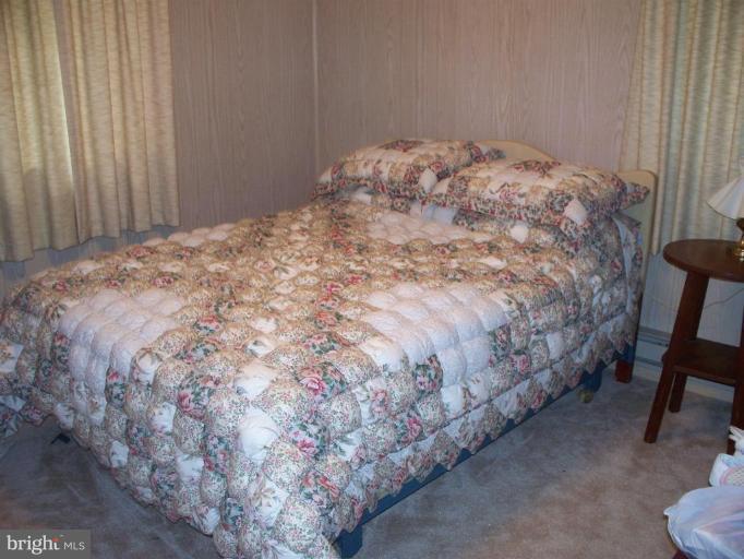 2818 Tabor Road Berkeley Springs, WV 25411 - Photo 4 of 21 a bed sitting in a bedroom next to a chair