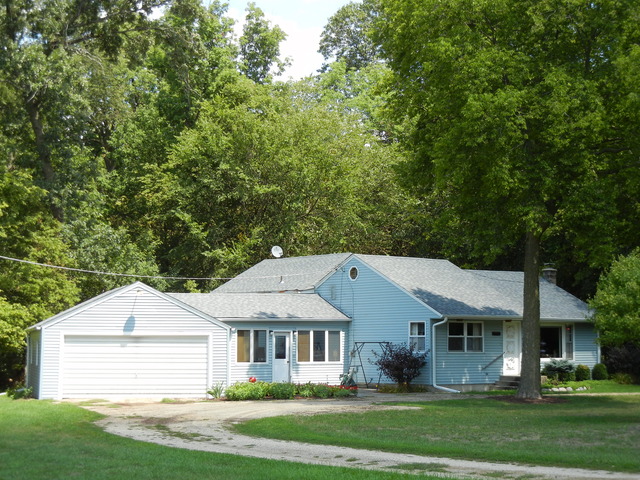 7014 East McCormick Road Stillman Valley, IL 61084 - Photo 1 of 13 a front view of a house with a garden and plants