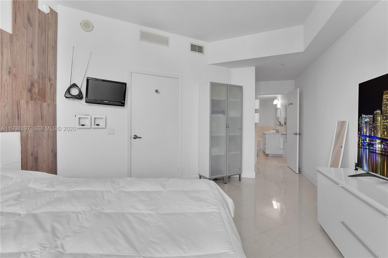 60 Southwest 13th Street, Unit 4818 Miami, FL 33130 - Photo 19 of 19 a spacious bedroom with a bed and a flat screen tv