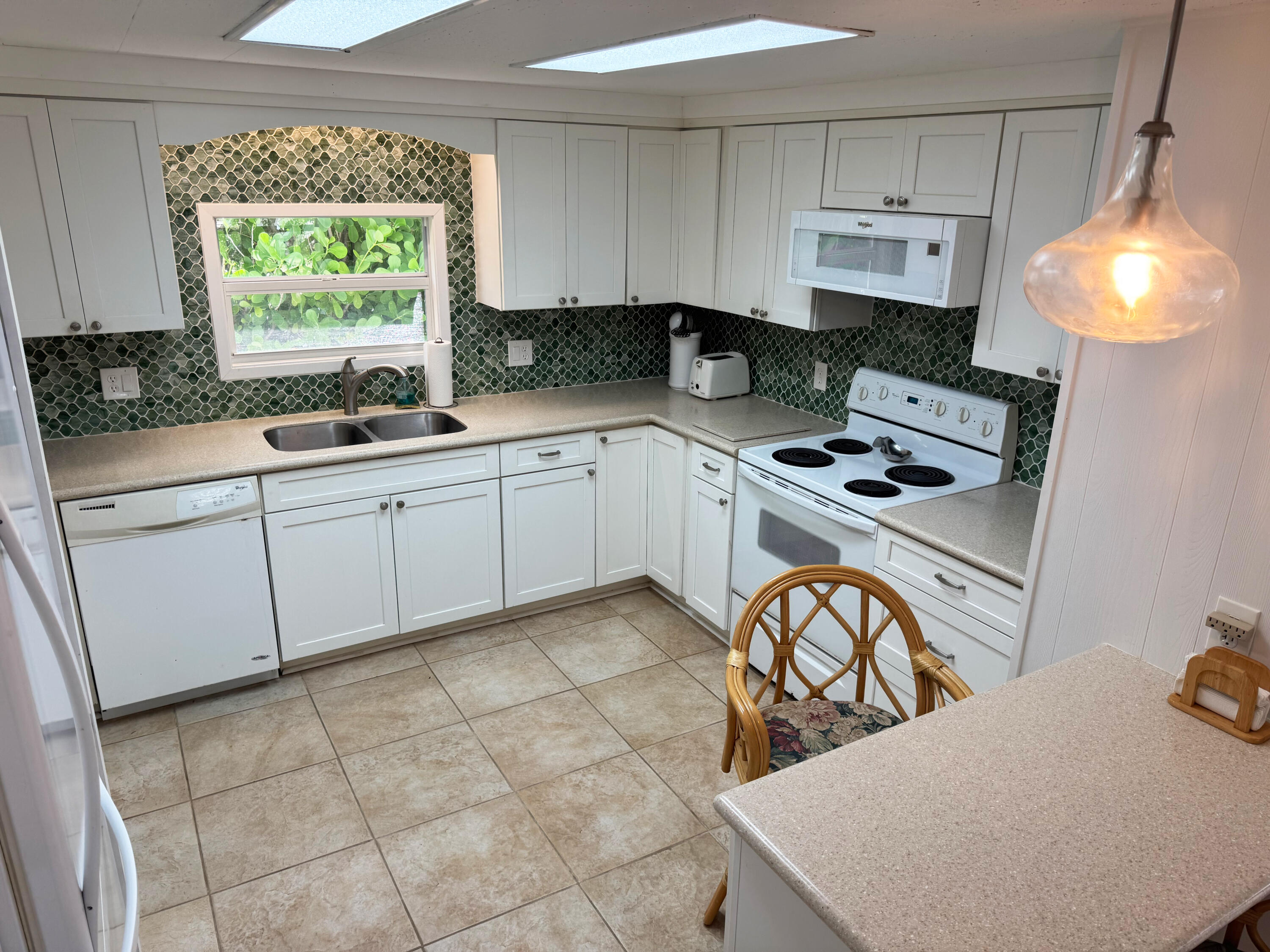 205 South Ibis Drive, Unit R Briny Breezes, FL 33435 - Photo 15 of 38 a kitchen with stainless steel appliances a stove a sink a counter space and a window