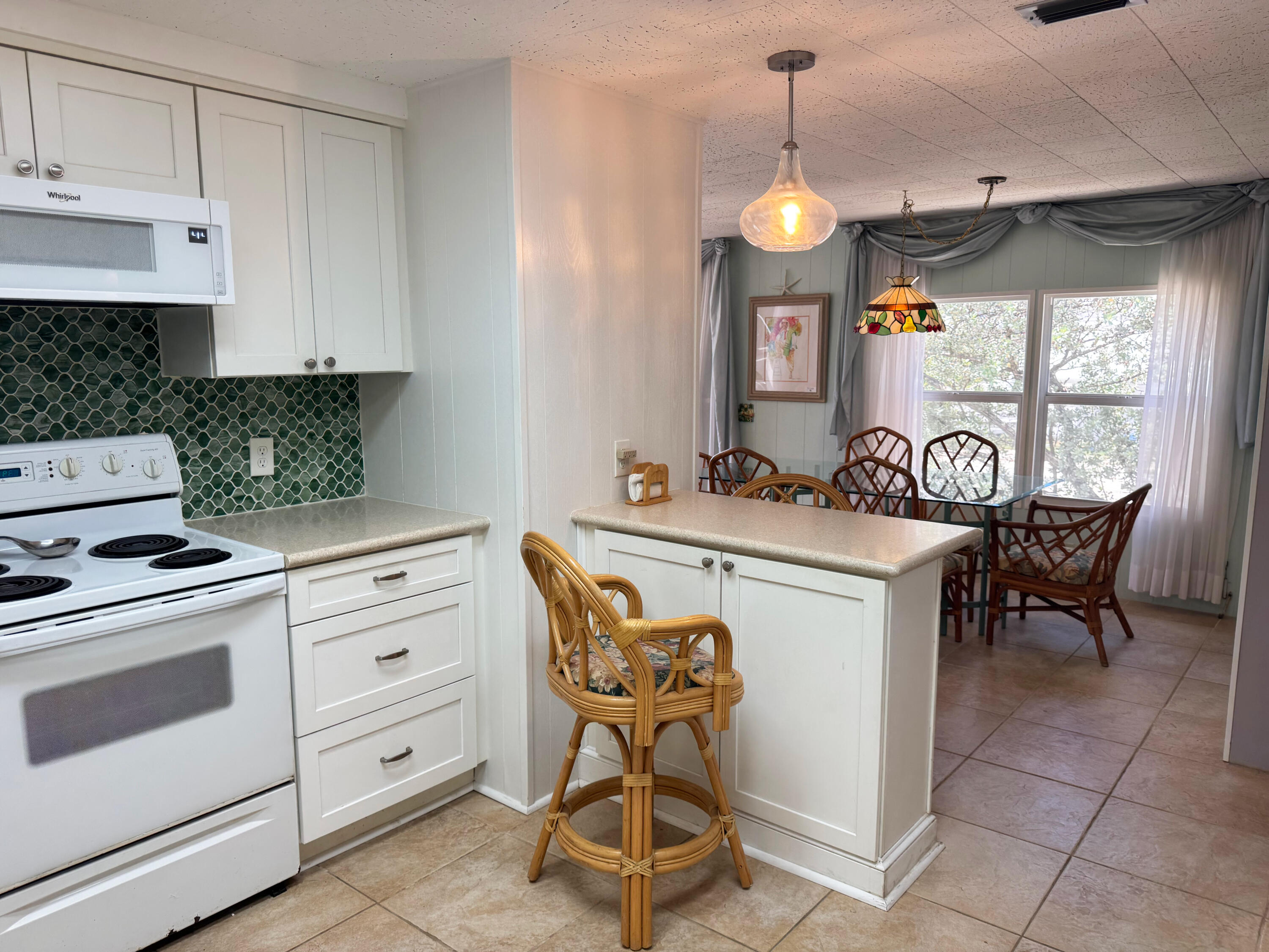 205 South Ibis Drive, Unit R Briny Breezes, FL 33435 - Photo 19 of 38 a kitchen with stainless steel appliances granite countertop a stove a sink a dining table and chairs with the cabinets