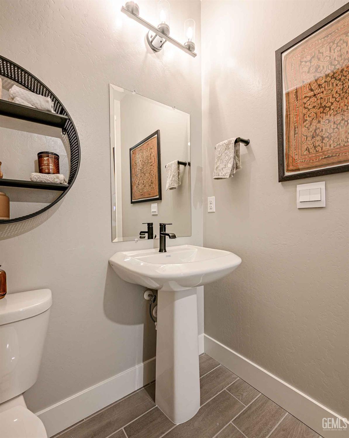 Undisclosed Address Bakersfield, CA 93313 - Photo 27 of 27 a bathroom with a sink a mirror and a toilet