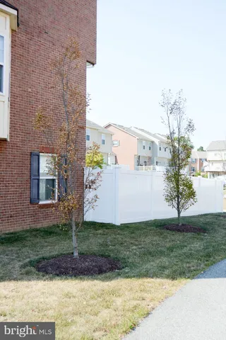 a view of backyard with barbeque grill and wooden fence