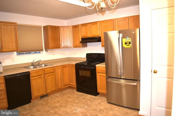 a kitchen with stainless steel appliances granite countertop a refrigerator a sink and dishwasher
