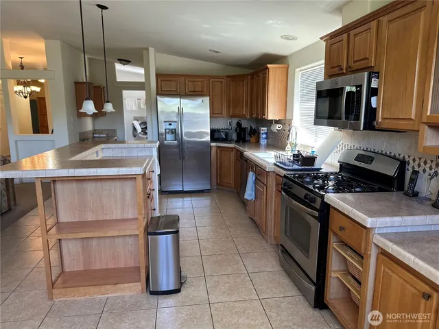 a kitchen with stainless steel appliances granite countertop a stove a sink and a refrigerator