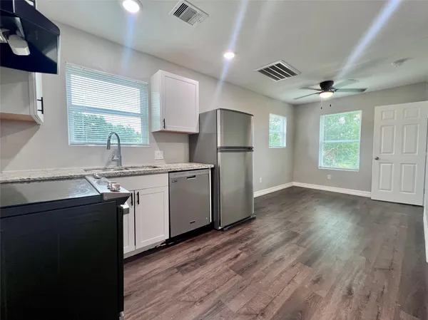 a kitchen with a sink window and cabinets