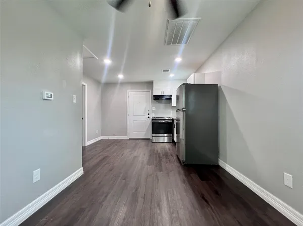 a view of kitchen with refrigerator microwave and wooden floor