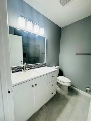 a bathroom with a sink and mirror with toilet