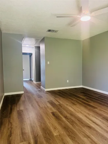 a view of an empty room with wooden floor