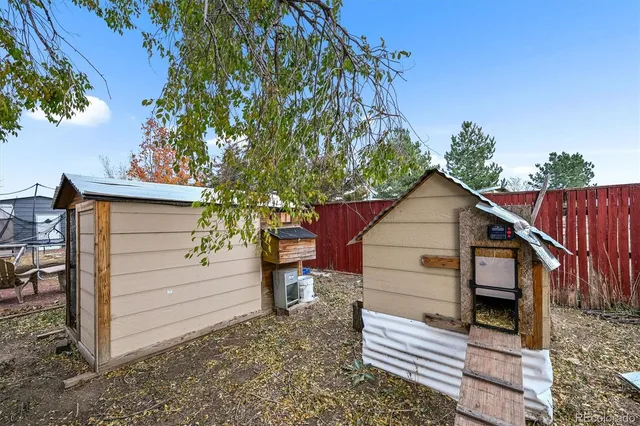 a view of a wooden house with a small yard and large tree
