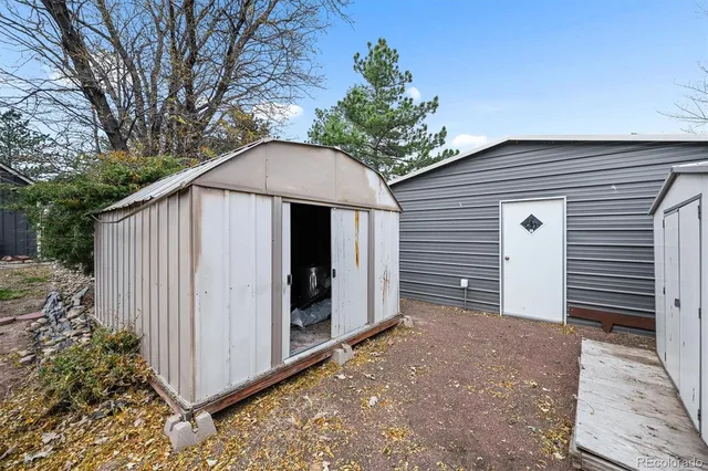 a front view of house with yard and trees in the background