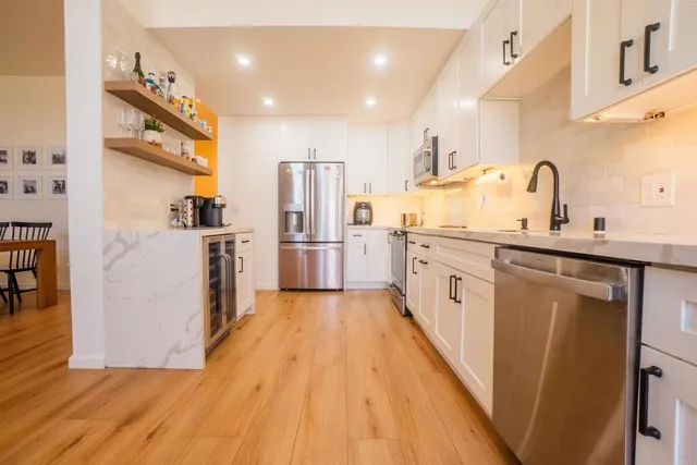 a kitchen with stainless steel appliances granite countertop a refrigerator and a sink