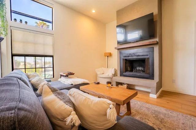 a living room with furniture a flat screen tv and a fireplace