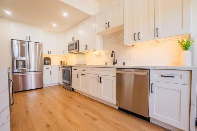 a kitchen with stainless steel appliances a refrigerator sink and cabinets