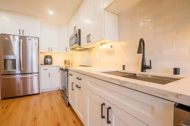 a kitchen with a sink refrigerator and microwave