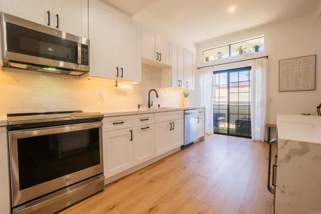 a kitchen with stainless steel appliances a stove microwave and sink