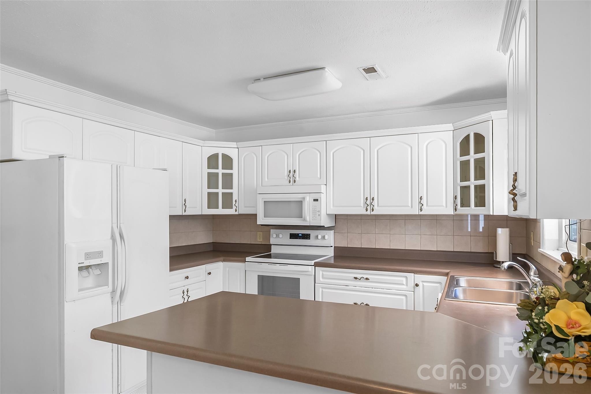 512 Paxton Creek Road Marion, NC 28752 - Photo 11 of 34 a kitchen with granite countertop a refrigerator sink and white cabinets