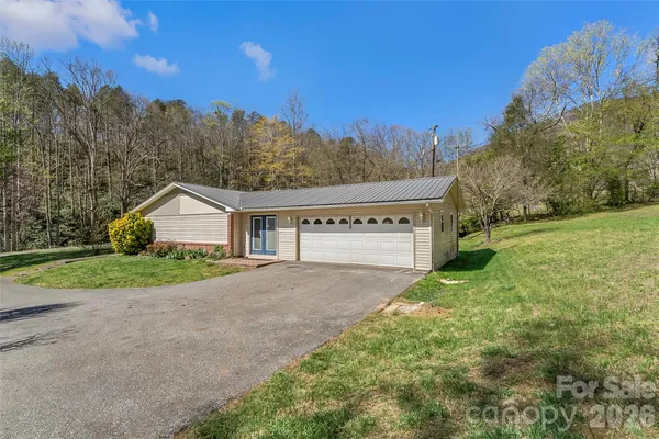 a view of a house with a yard and garage