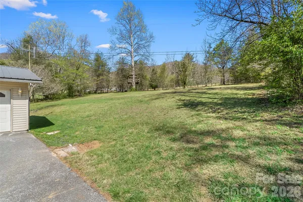 a view of a field of grass and trees