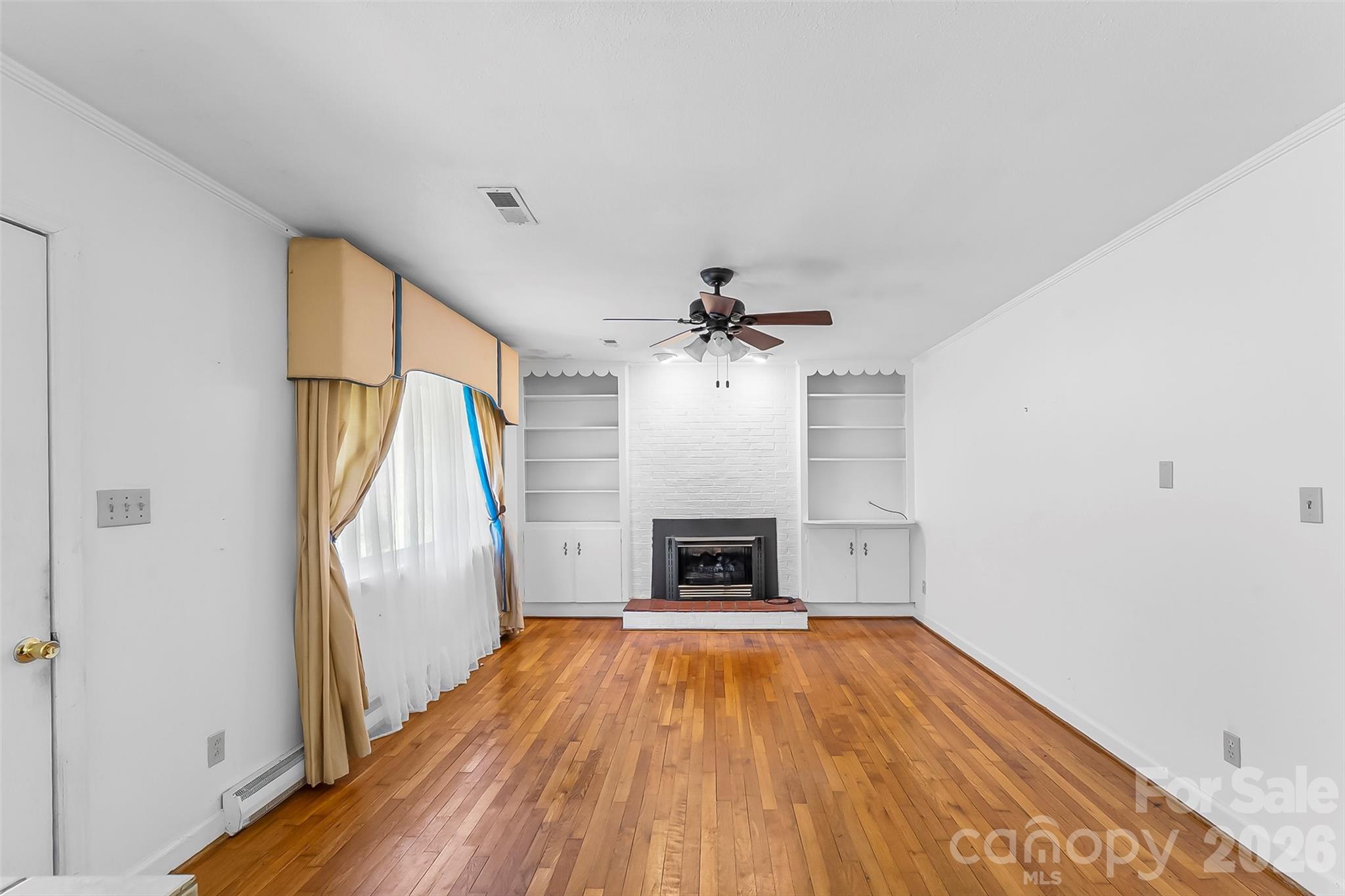 512 Paxton Creek Road Marion, NC 28752 - Photo 6 of 34 wooden floor in an empty room with a fireplace