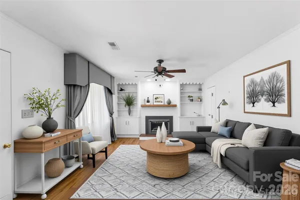 a living room with furniture a fireplace and a chandelier